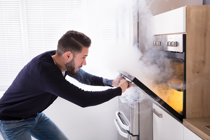 Man burning food in oven