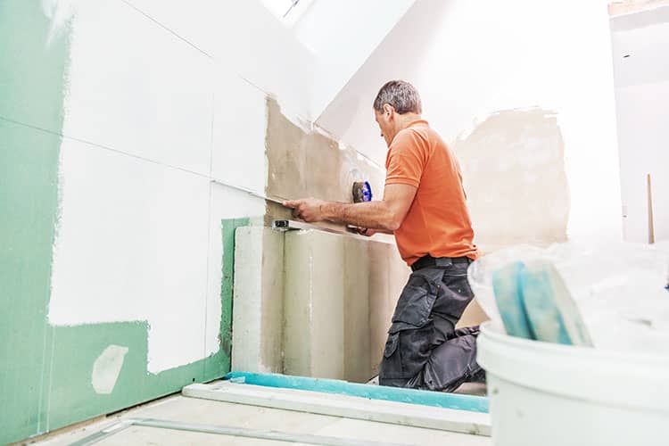 Plasterer re-plastering a bathroom during home renovation.