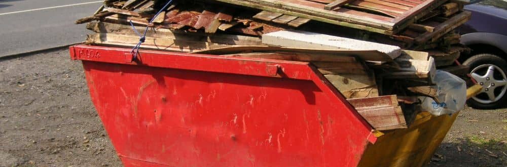 Dangerously overloaded red skip bin.