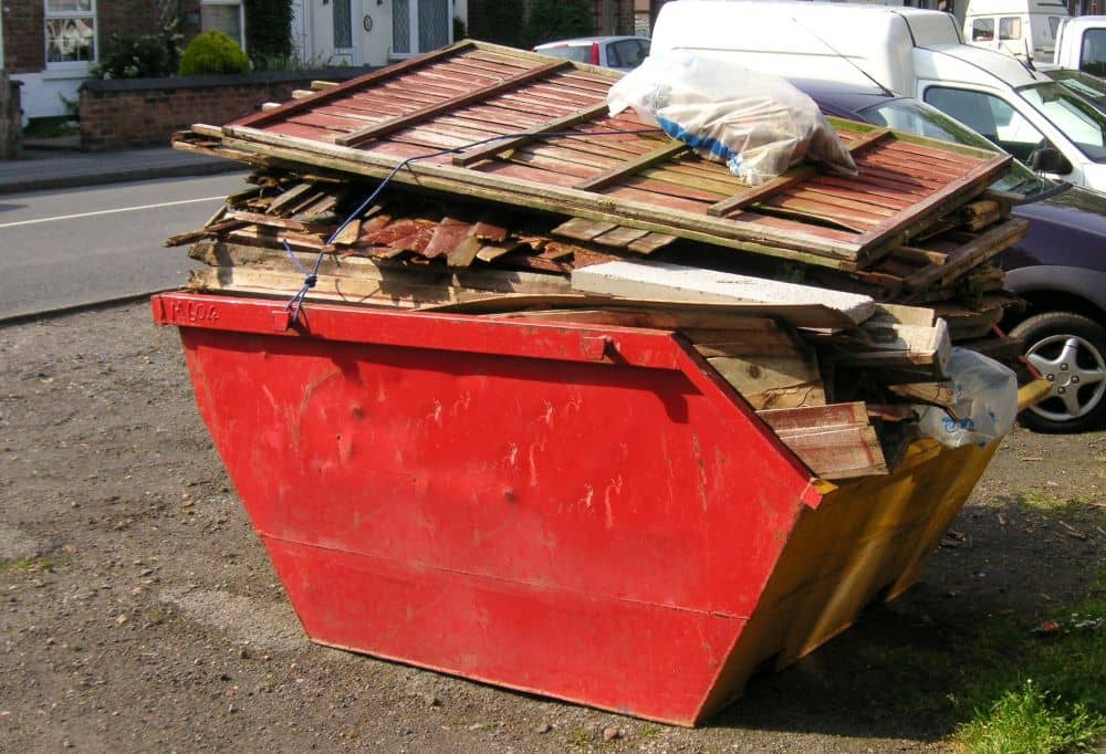 Dangerously overloaded red skip bin.