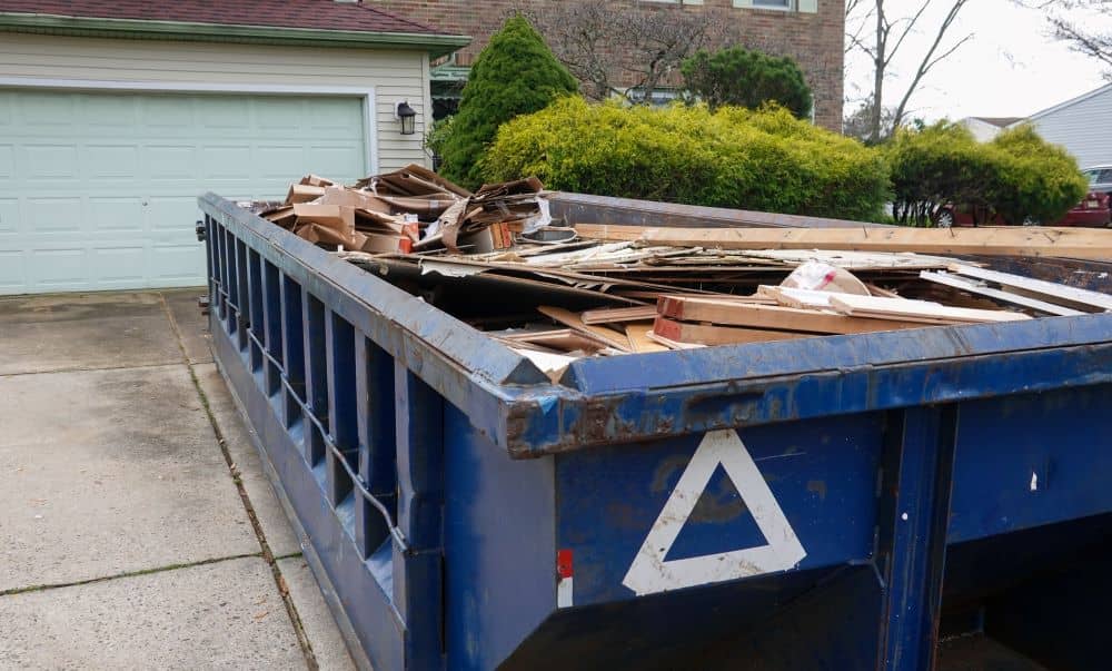 Skip on the driveway filled with debris.