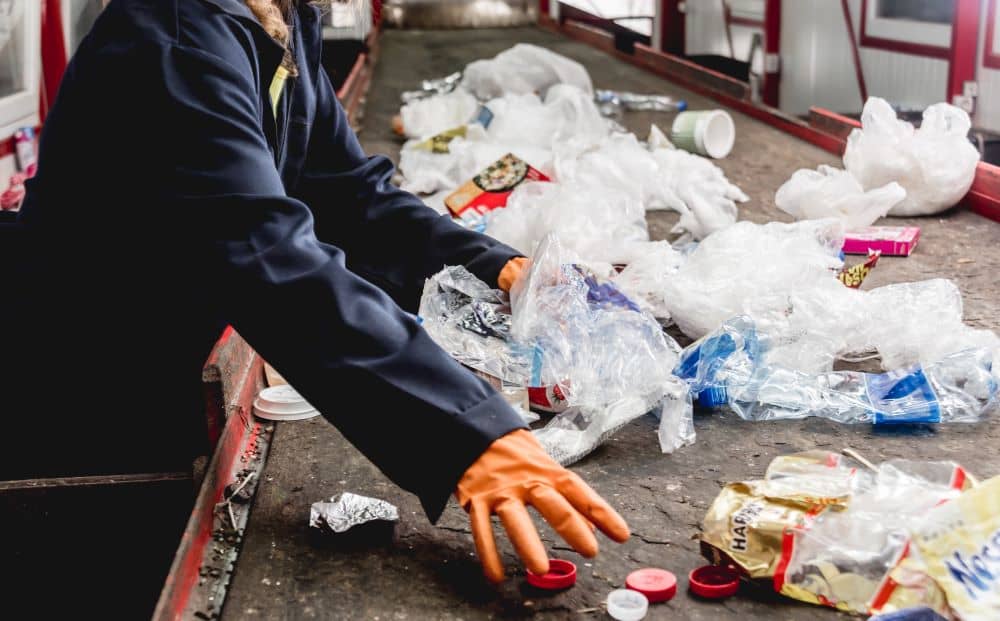 The skip bin's contents are sorted into different categories at a rubbish transfer station.